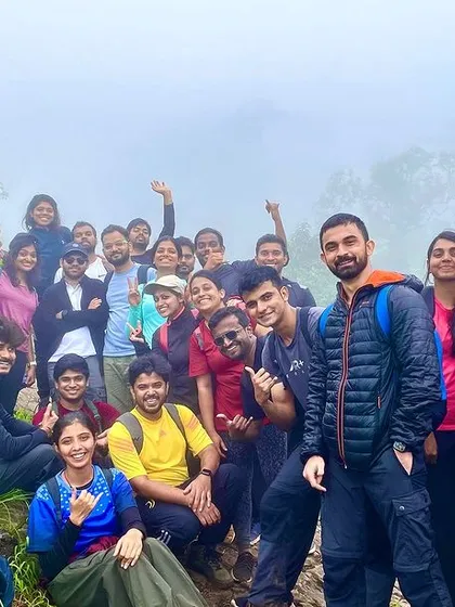 A large group posing in a lush green meadow, with some members making funny faces. We encourage a fun and lighthearted atmosphere on our treks.