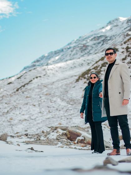 A dramatic pose against a vast, snowy landscape, capturing the scale and beauty of the Himalayas.