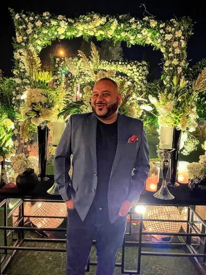 That wedding season smile. Standing in front of a beautifully decorated floral arch, ready to bring the music.