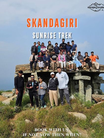 A promotional image for our Skandagiri Sunrise Trek, showing a group at the iconic stone structure on the peak.