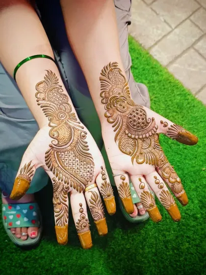 A classic Arabic design with a prominent paisley and floral trail. The fingers are adorned with matching patterns, and the tips are covered for a rich stain.