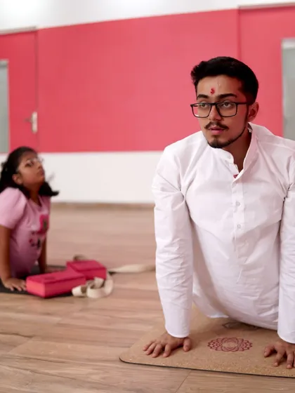 Here, I am guiding a young student through Bhujangasana, or Cobra Pose. It’s a simple yet powerful posture for strengthening the back and opening the heart. My focus is always on providing hands-on, gentle guidance to ensure every child learns safely and feels confident in their practice.
