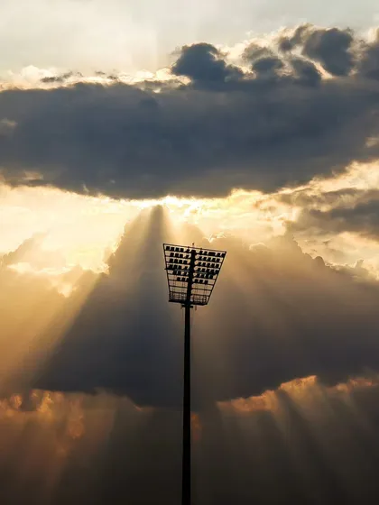The story of a match begins before the players even take the field. This shot of the stadium floodlight against the evening sky captures the quiet anticipation and grand scale of a major sporting event.