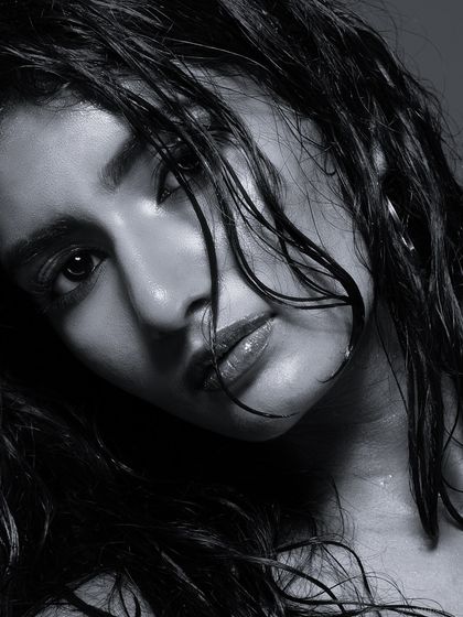 An intense black and white close-up of a model with the high-fashion wet hair look. This shot emphasizes texture, emotion, and dramatic lighting.
