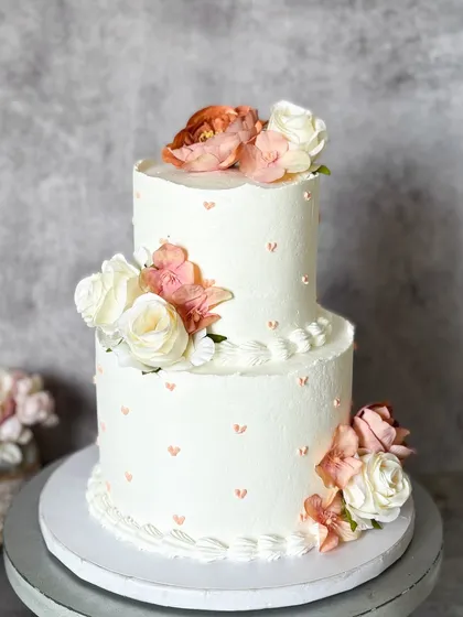 Two tiers of love, frosted in delicious Belgian chocolate. This cake, decorated with fresh flowers and tiny hearts, is a beautiful centerpiece for any wedding or engagement party.