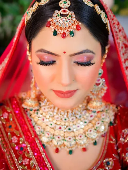 A close-up shot focusing on the stunning eye makeup and the intricate details of the bridal jewelry.
