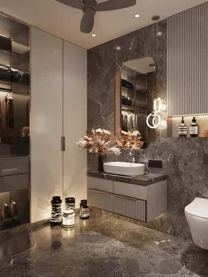 We kept the base neutral yet added a blingy twist to this bathroom design. The dark grey marble provides a moody backdrop for the modern vanity, halo-lit mirror, and an integrated walk-in closet section with glass doors and internal lighting.