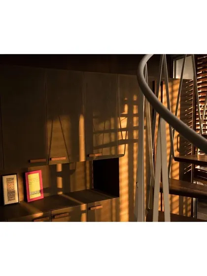 The shifting shadows cast by the twisting steel members of the spiral staircase create beautiful, dynamic patterns on the wooden cabinetry throughout the afternoon. This is an example of how I use architecture to engage with the daily passage of light.