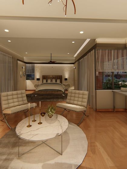 This image shows the full layout of the master suite, from the seating area in the foreground to the bed and workspace in the background. The open-plan design creates a luxurious and multi-functional retreat.