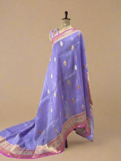 A beautiful lilac pure Kora organza saree with leaf-shaped Meenakari butis and a pink and gold border.