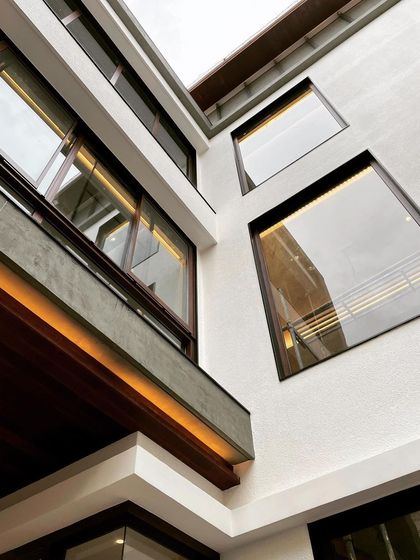 A detail shot of a residence under construction, focusing on the window placement and exterior lighting.