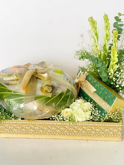 A roka hamper featuring a fruit basket and gift box, presented in an ornate gold tray and decorated with fresh white roses and tuberoses.