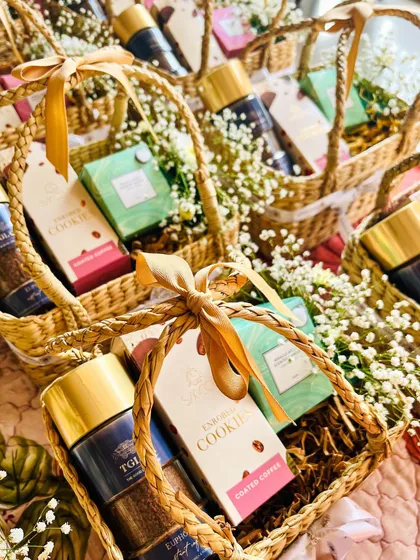 These charming woven baskets are perfect as elegant wedding favours or bridesmaid gifts. Each one is filled with gourmet cookies and premium coffee, adorned with delicate baby's breath flowers and a simple beige ribbon for a touch of rustic elegance.