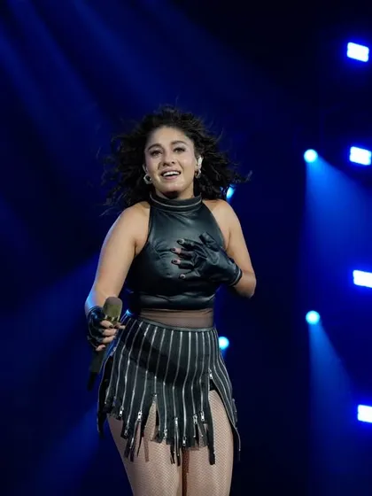 A candid shot of Sunidhi mid-performance, full of joy and energy.