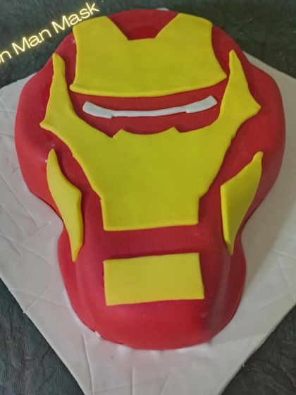 A 3D sculpted Iron Man mask cake. This realistic design is perfect for a Marvel fan and shows my ability to create impressive, three-dimensional character cakes.
