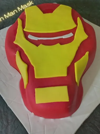A 3D Iron Man mask cake that looks just like the real thing. This sculpted cake is a fantastic choice for any Marvel superhero fan.
