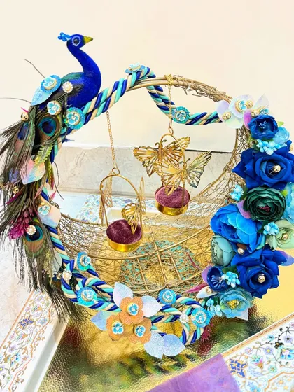A ring platter should be as special as the moment itself. We designed this custom peacock-themed ring platter with vibrant blue florals and intricate feather details to create a royal stage for the rings. It’s a piece that truly celebrates the promise of a lifetime together.