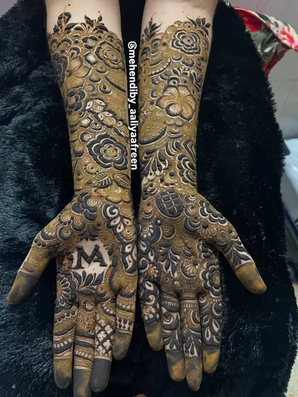 A different view of the intricate bridal mehendi, showing the beautiful flow of the design from the palm to the forearm.