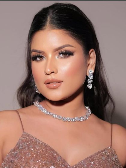 A glamorous look perfect for a cocktail party or reception. The makeup features shimmery eyes, glowing skin, and a glossy nude lip.