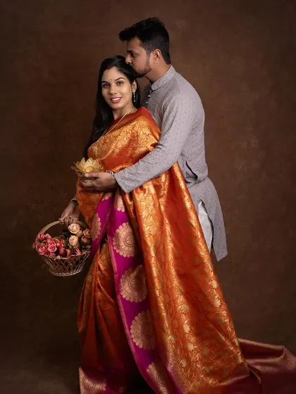A gentle kiss and a happy smile. This pose captures the protective and loving nature of the father to be as he embraces his wife. The traditional attire makes this portrait a celebration of their heritage.