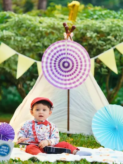A festive picnic-themed setup in a park, complete with a teepee tent, gifts, and colorful decorations. This is a great option for a vibrant pre-birthday shoot.