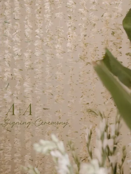 A close-up detail of the floral backdrop from the signing ceremony, showing the texture and delicate nature of the hanging tuberose strings.