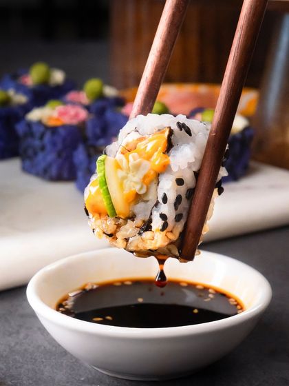A satisfying shot of the Cucumber Cream Cheese roll being dipped into soy sauce.