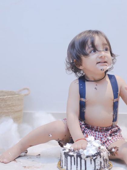 This little guy is getting right into his first birthday cake. We love capturing the hilarious and heartwarming chaos of a cake smash.