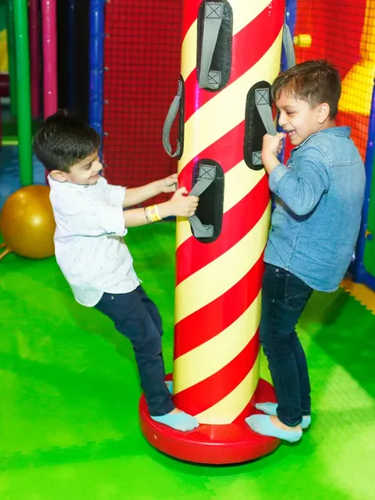 Two boys work together to spin on one of our merry-go-round features. It's a great activity for building teamwork and coordination.