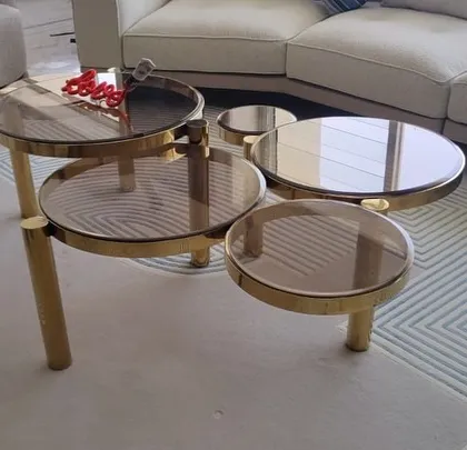 Another view of the Aarhus multi-level coffee table, showing its dynamic composition and the warm tint of the glass tops.
