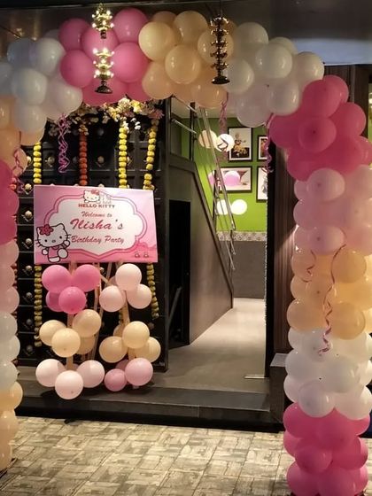 The entrance to the Hello Kitty party, with a custom welcome sign and a colorful balloon arch.