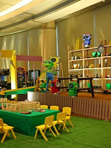 An overview of the Gecko's Garage party, set up like a real workshop and arcade. It features a prize station, kids' activity tables, and various arcade games for entertainment.