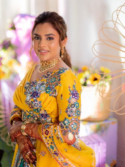 This portrait shows how the makeup beautifully complements the intricate embroidery of the haldi outfit.