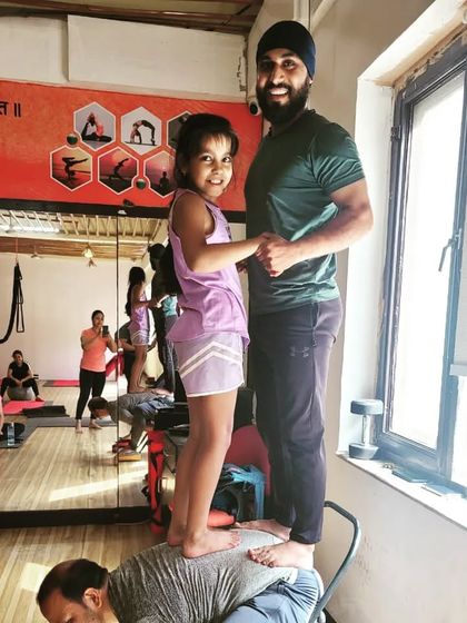 A playful moment in class. This demonstrates how we can use our bodies and even chairs as props to build strength, balance, and trust.