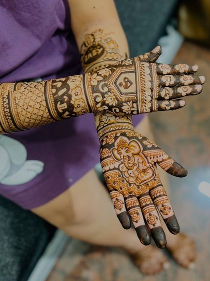 This design for a mom-to-be includes a charming baby Ganesha on the palm for blessings. The forearms are decorated with patterns of baby clothes, bottles, and toys.