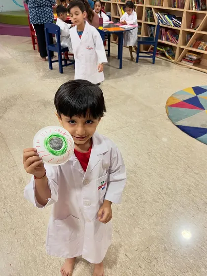 A young scientist proudly holds up the eyeball model he made during our science camp. Hands-on crafts make learning about biology much more memorable.