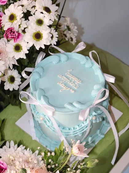 A close-up of the "Happy Women's Day" mini cake from our beautiful cake and flower hamper.