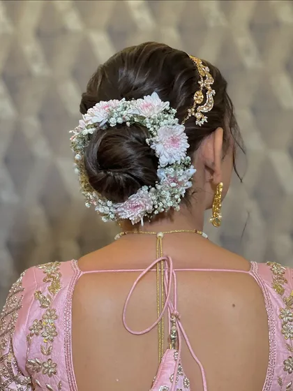 A close-up of the floral bun, highlighting the intricate details of the flowers and the elegant hair accessory.