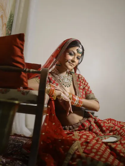 A candid, artistic shot of the bride. The soft lighting highlights the intricate details of her makeup, from the perfectly blended eyeshadow to the subtle contouring.