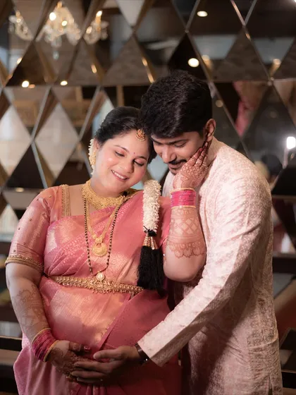 During a traditional Godh Bharai ceremony, there are so many moments of quiet love. Here, the father-to-be gently holds his wife and their baby bump, a beautiful portrait of support and shared joy.
