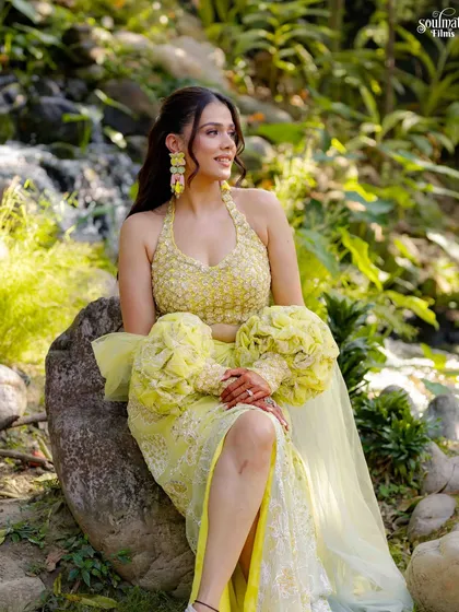 A solo portrait of the bride-to-be from the garden shoot. Her vibrant yellow lehenga with unique puff sleeves stands out beautifully against the natural greenery, showcasing her unique bridal style.