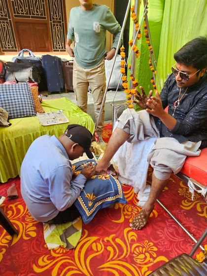 This shot captures the focus and dedication that goes into every groom's mehndi session, whether it's on the hands or the feet.