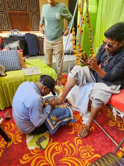 This shot captures the focus and dedication that goes into every groom's mehndi session, whether it's on the hands or the feet.