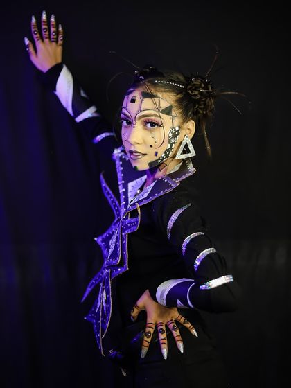 An abstract, geometric makeup look with sharp lines and metallic accents.