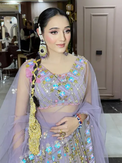 A flawless makeup look for a Lohri celebration. The lavender lehenga is paired with soft, glowing makeup and a traditional Punjabi braid (parandi).
