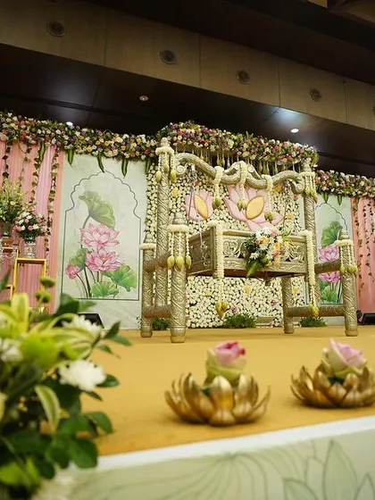 A low-angle shot of the 'Lotus Love' stage, emphasizing the depth and layers of the decor, from the foreground floral accents to the main backdrop.