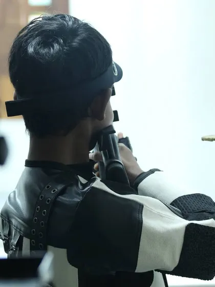 A close up view from behind a shooter, showing the concentration required to align the sights with the target. This is the core of precision marksmanship.
