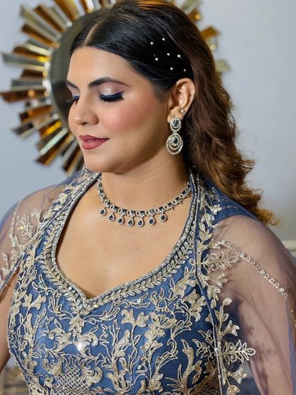 A side profile showcasing the elegant half-ponytail and the precise eye makeup. The hair is adorned with a simple, sparkling accessory.