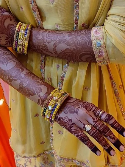 The rich stain of this Indo-Arabic design looks so beautiful against the client's yellow outfit. The dark fingertips and palms are a classic look.