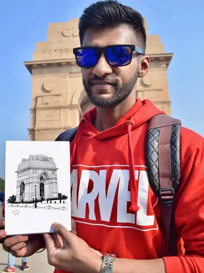 Standing in front of India Gate in Delhi with a pen sketch I drew on location. I enjoy urban sketching and capturing the beauty of architectural landmarks.